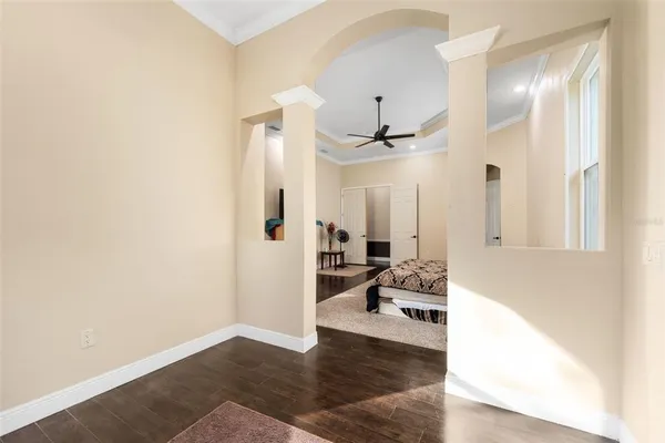 an empty room with windows and fan