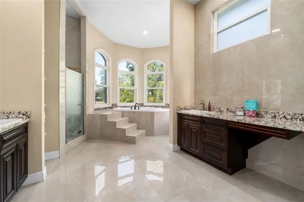 a bathroom with a tub a sink and a window