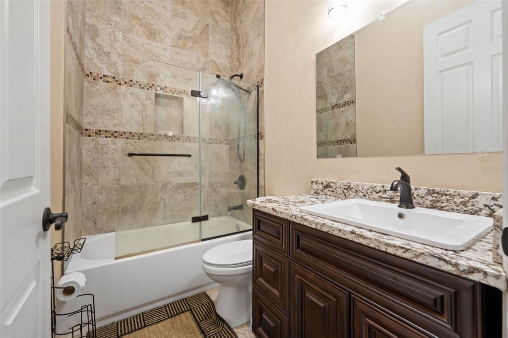16635 Southwest 139th Avenue Archer, FL 32618 - Photo 30 of 48 a bathroom with a granite countertop sink toilet and shower