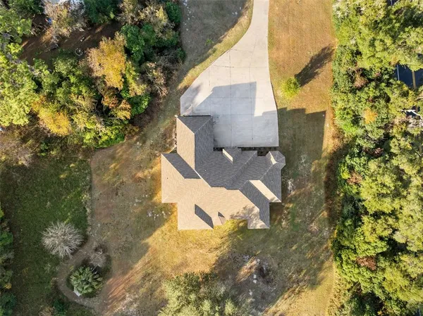 an aerial view of residential houses with outdoor space and trees
