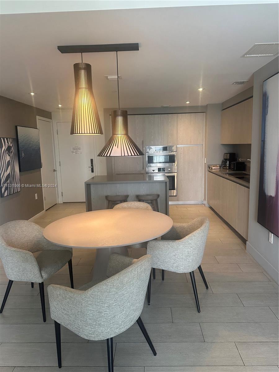 4010 South Ocean Drive, Unit R707 Hollywood, FL 33019 - Photo 18 of 70 a kitchen with stainless steel appliances kitchen island a table and chairs in it