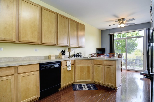 565 Springbrook Trail North Oswego, IL 60543 - Photo 11 of 21 a kitchen with stainless steel appliances granite countertop a sink and cabinets