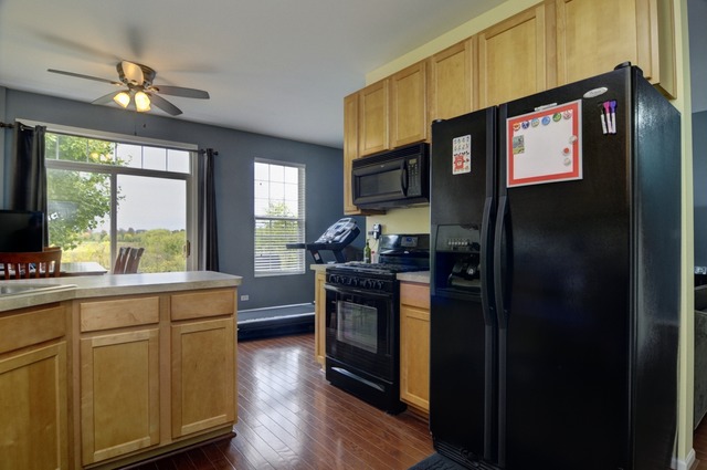 565 Springbrook Trail North Oswego, IL 60543 - Photo 12 of 21 a kitchen with stainless steel appliances granite countertop a refrigerator a stove a sink and dishwasher with wooden floor