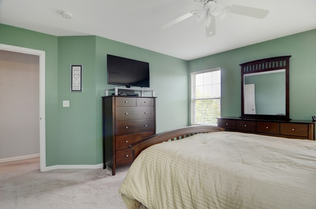 565 Springbrook Trail North Oswego, IL 60543 - Photo 16 of 21 a bedroom with a bed and a flat screen tv
