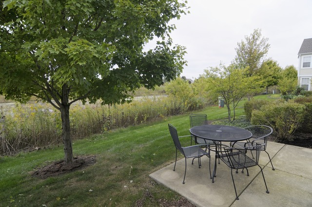 565 Springbrook Trail North Oswego, IL 60543 - Photo 3 of 21 a view of a chairs and table in backyard of the house