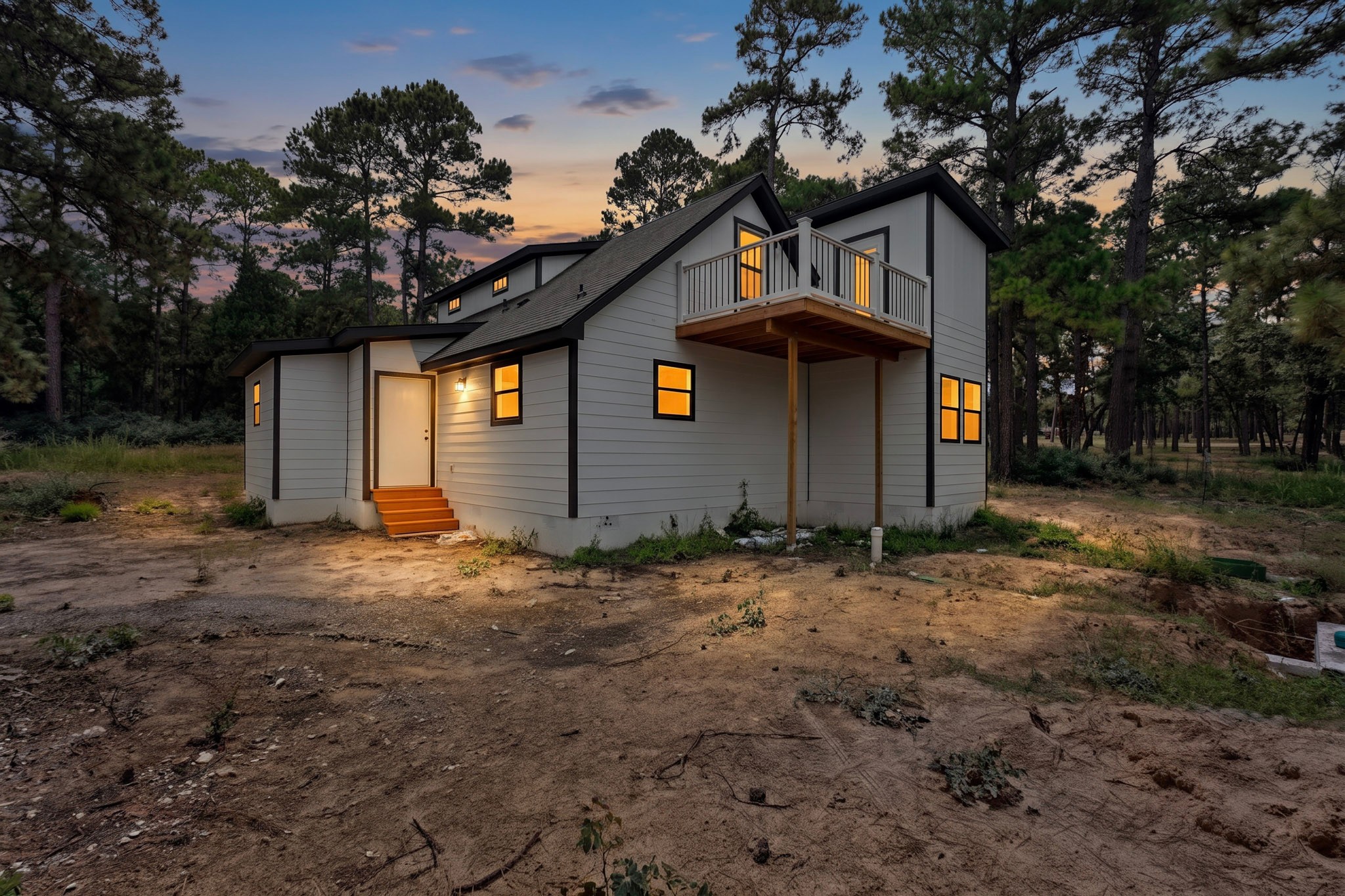 158 Fealy Road Red Rock, TX 78662 - Photo 35 of 40 Crisp siding and a private balcony accent this wooded multi-level home under twilight skies.