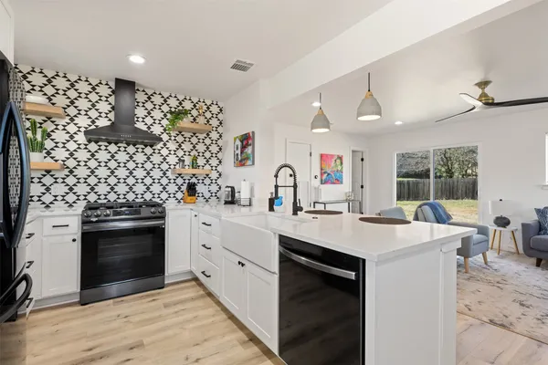 a kitchen with a sink stove and wooden floor