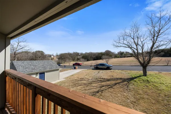 a view of a dry yard with wooden fence