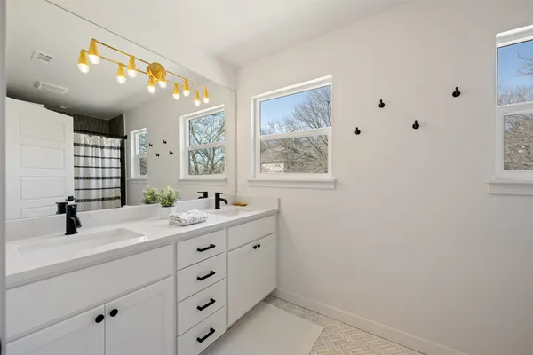 a bathroom with a double vanity sink toilet and a mirror