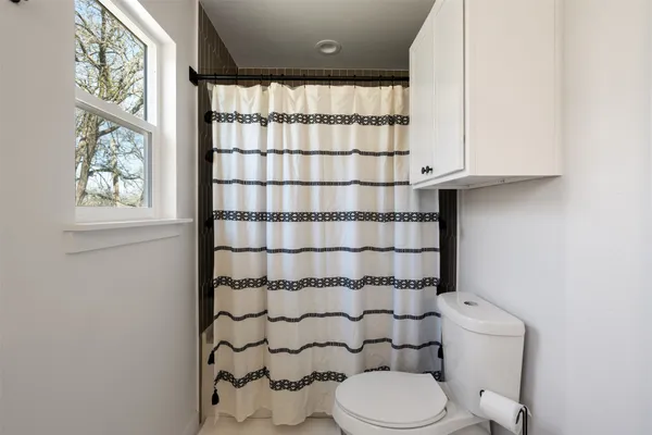 a bathroom with a toilet and a shower curtain