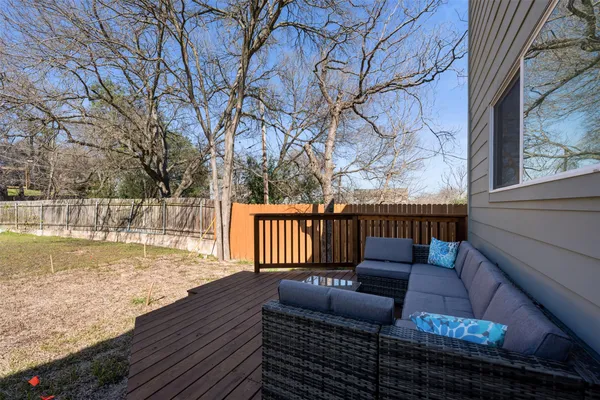 a balcony with wooden floor table and chairs