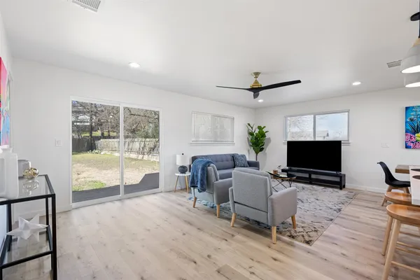 a living room with furniture a flat screen tv and a large window
