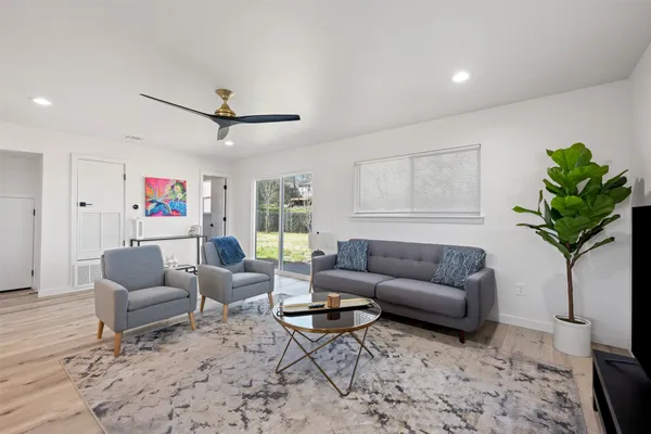 a living room with furniture a chandelier and a potted plant