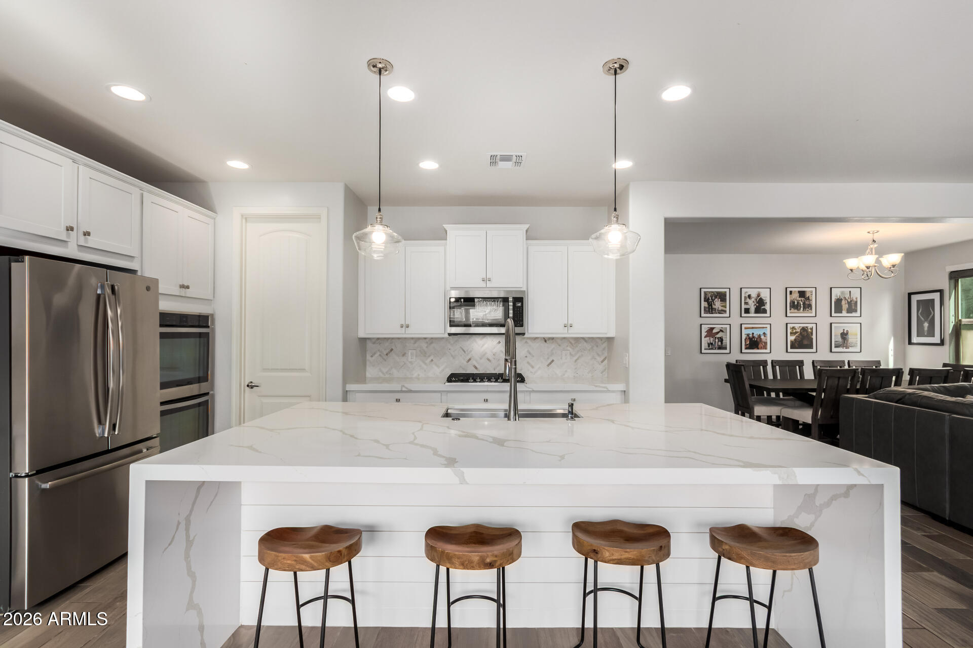 22083 East Camacho Road Queen Creek, AZ 85142 - Photo 17 of 42 a kitchen with stainless steel appliances a dining table chairs refrigerator and microwave