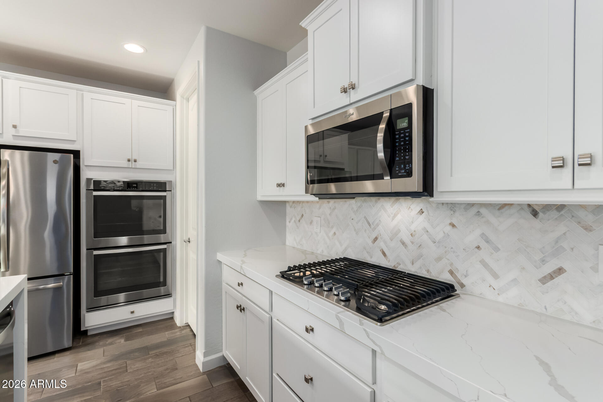 22083 East Camacho Road Queen Creek, AZ 85142 - Photo 18 of 42 a kitchen with stainless steel appliances a stove a microwave and a refrigerator
