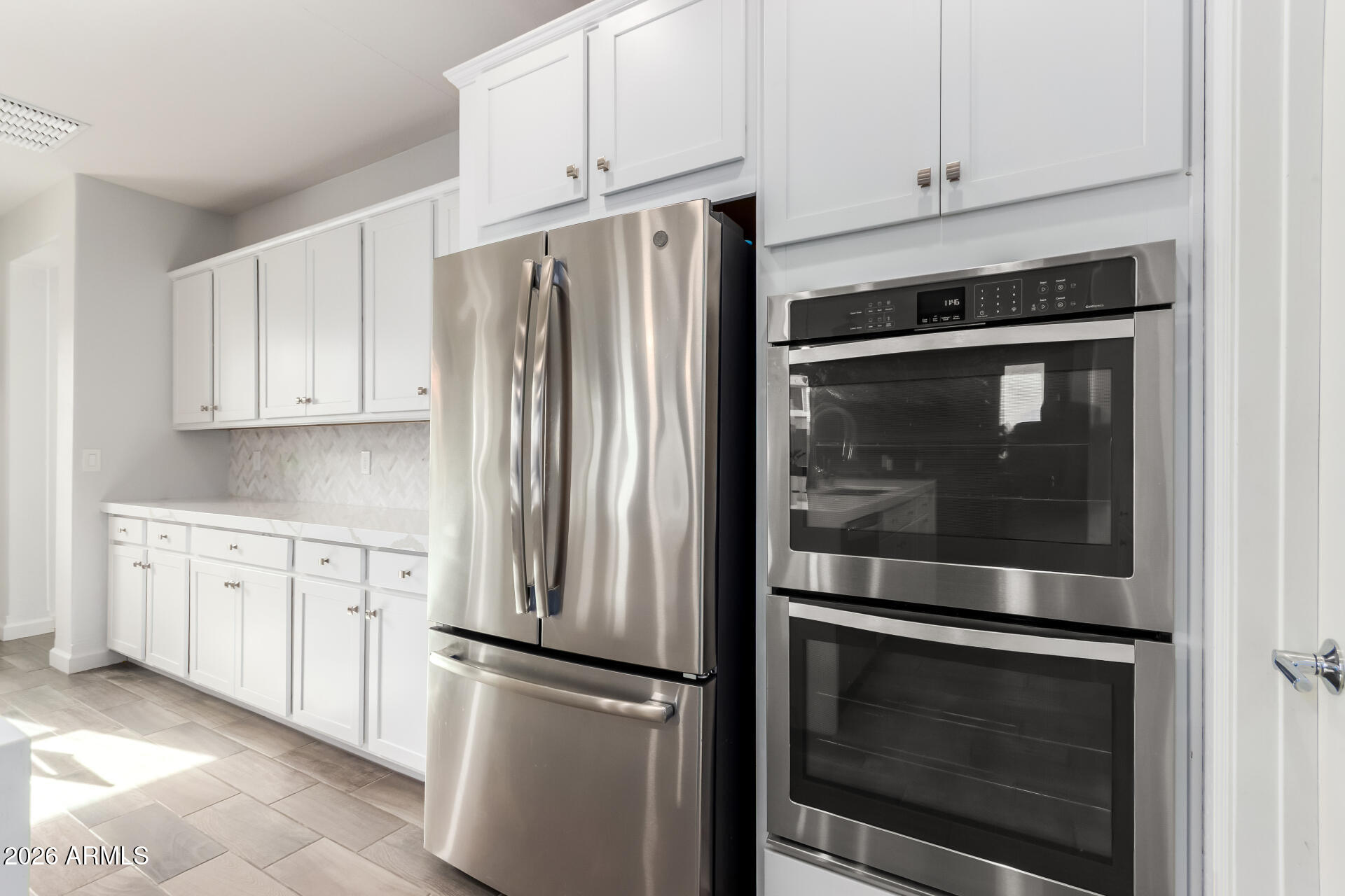 22083 East Camacho Road Queen Creek, AZ 85142 - Photo 19 of 42 a kitchen with stainless steel appliances white cabinets and a refrigerator