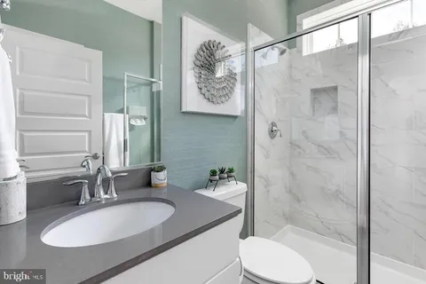 a bathroom with a sink toilet a mirror and shower