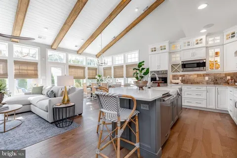 a view of kitchen with stainless steel appliances granite countertop a stove and cabinets