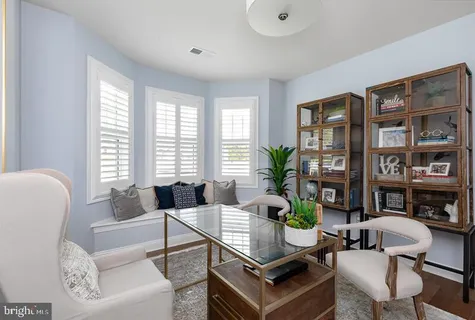 a living room with furniture a bookshelf and a large window