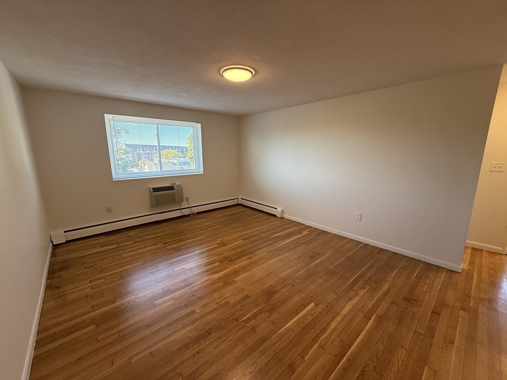 154 Main Street, Unit 32 Everett, MA 02149 - Photo 2 of 10 a view of room with wooden floor and window
