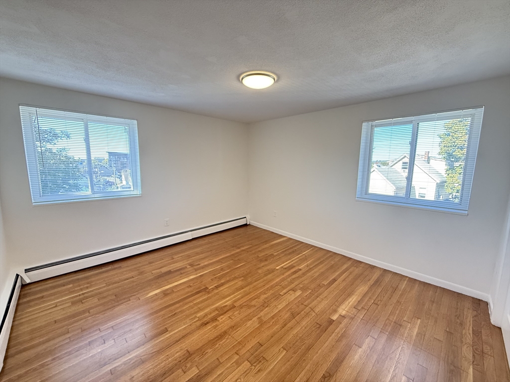 154 Main Street, Unit 32 Everett, MA 02149 - Photo 7 of 10 a view of an empty room with wooden floor and a window