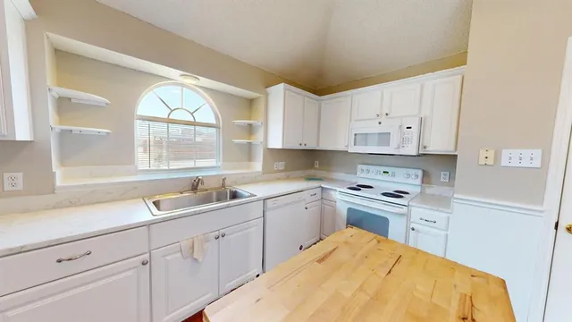 a kitchen with stainless steel appliances a refrigerator a sink dishwasher a stove with wooden floor and cabinets