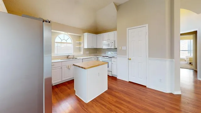 a kitchen with a refrigerator sink and cabinets