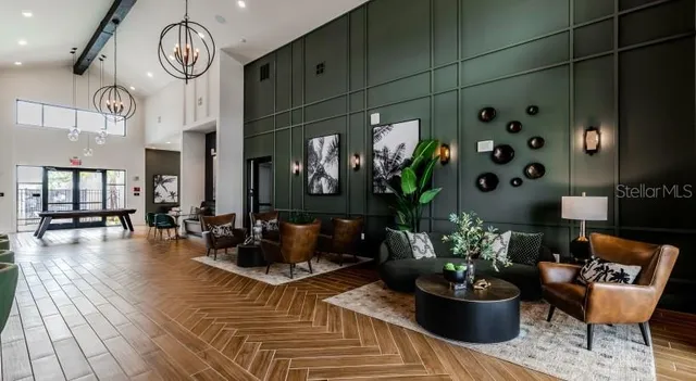 a living room with furniture a clock and a potted plant