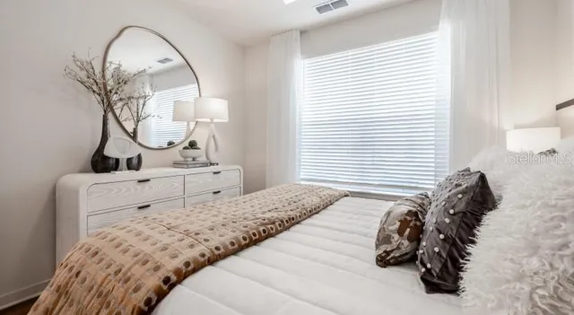 a bedroom with a bed and a mirror