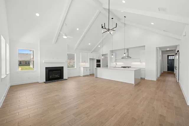 a view of kitchen and empty room with fireplace