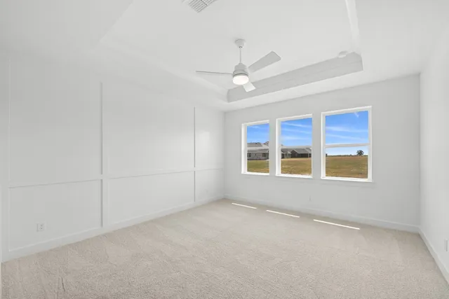 an empty room with a ceiling fan and window