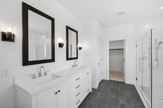a bathroom with double vanity sinks and a mirror