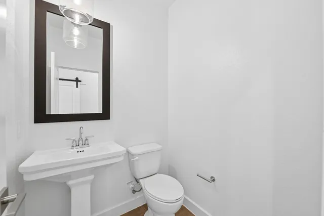 a bathroom with a toilet a sink and mirror