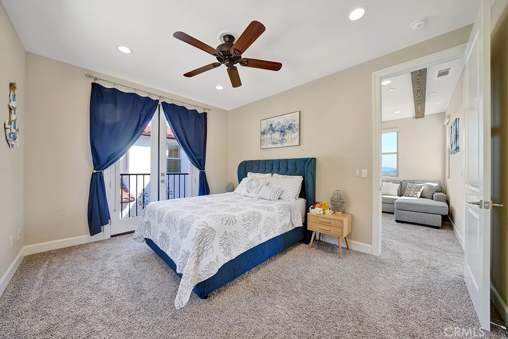 75 Marbella San Clemente, CA 92673 - Photo 43 of 54 a spacious bedroom with a bed a couch and a ceiling fan