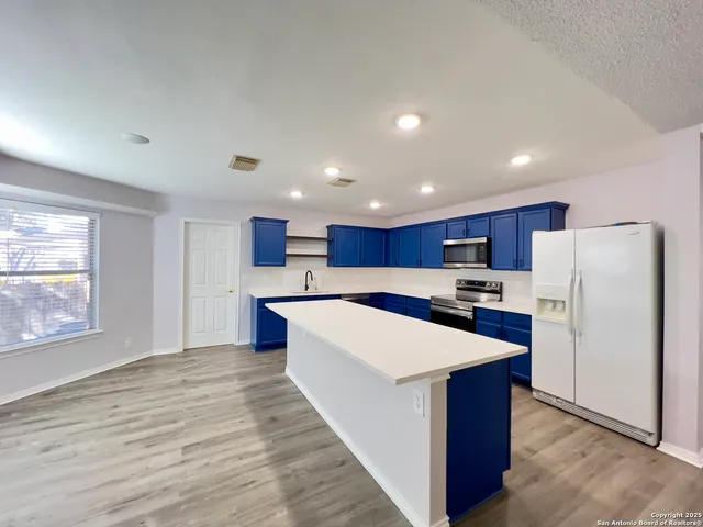 a kitchen with stainless steel appliances a refrigerator and a stove top oven