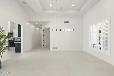 a large white kitchen with stainless steel appliances kitchen island granite countertop a refrigerator and a stove top oven