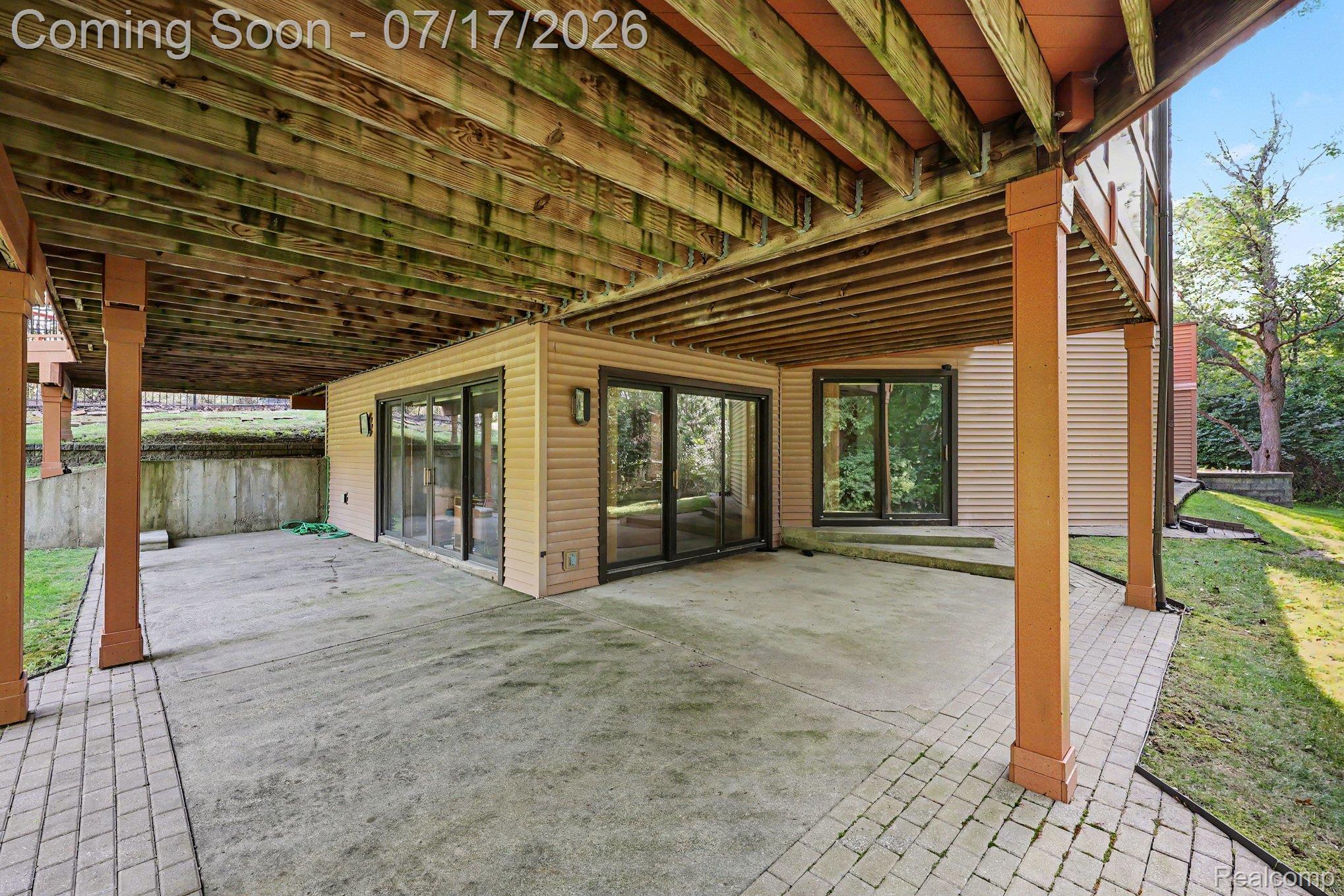 5685 Paint Valley Drive Rochester, MI 48306 - Photo 41 of 66 Expansive covered patio featuring a concrete surface and paver accents, supported by substantial wood columns