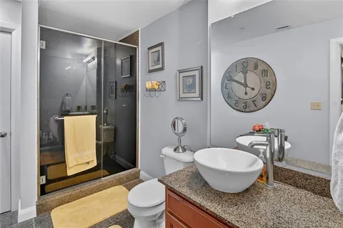 a bathroom with a granite countertop toilet a sink and a mirror