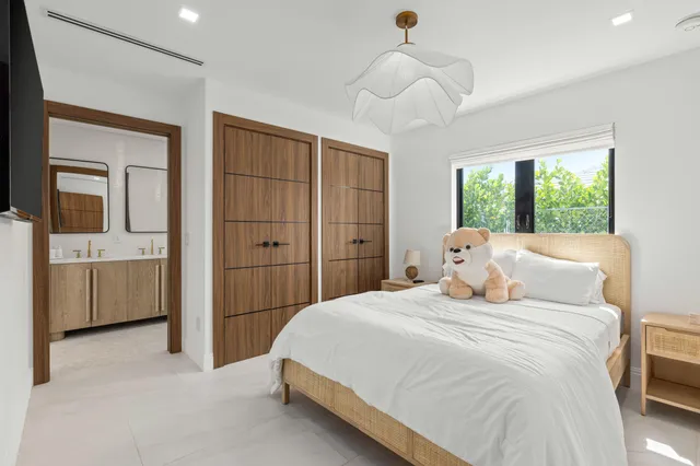 a bedroom with a large bed and a chandelier