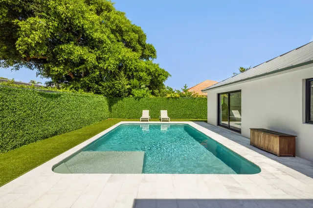 a view of backyard with table and chairs and potted plants