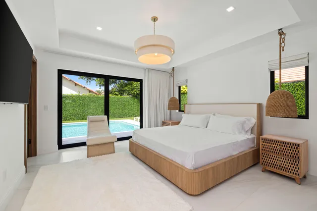 a bedroom with a bed couch and large window