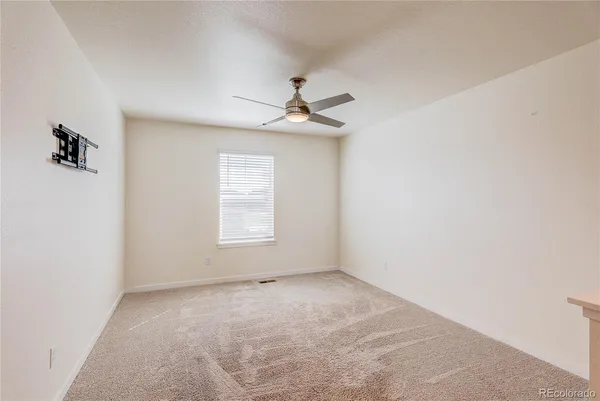 an empty room with a window and a ceiling fan