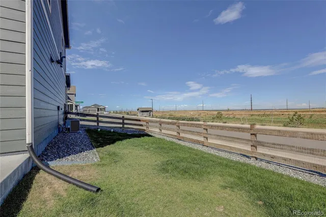 a view of a backyard with lawn chairs
