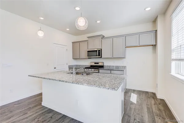 a kitchen with granite countertop a sink stainless steel appliances and cabinets