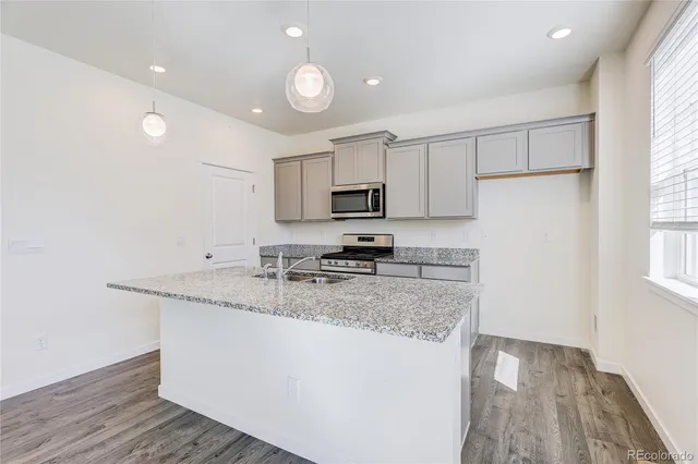 a kitchen with granite countertop a sink stainless steel appliances and cabinets