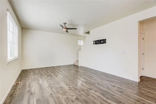 a view of empty room with wooden floor