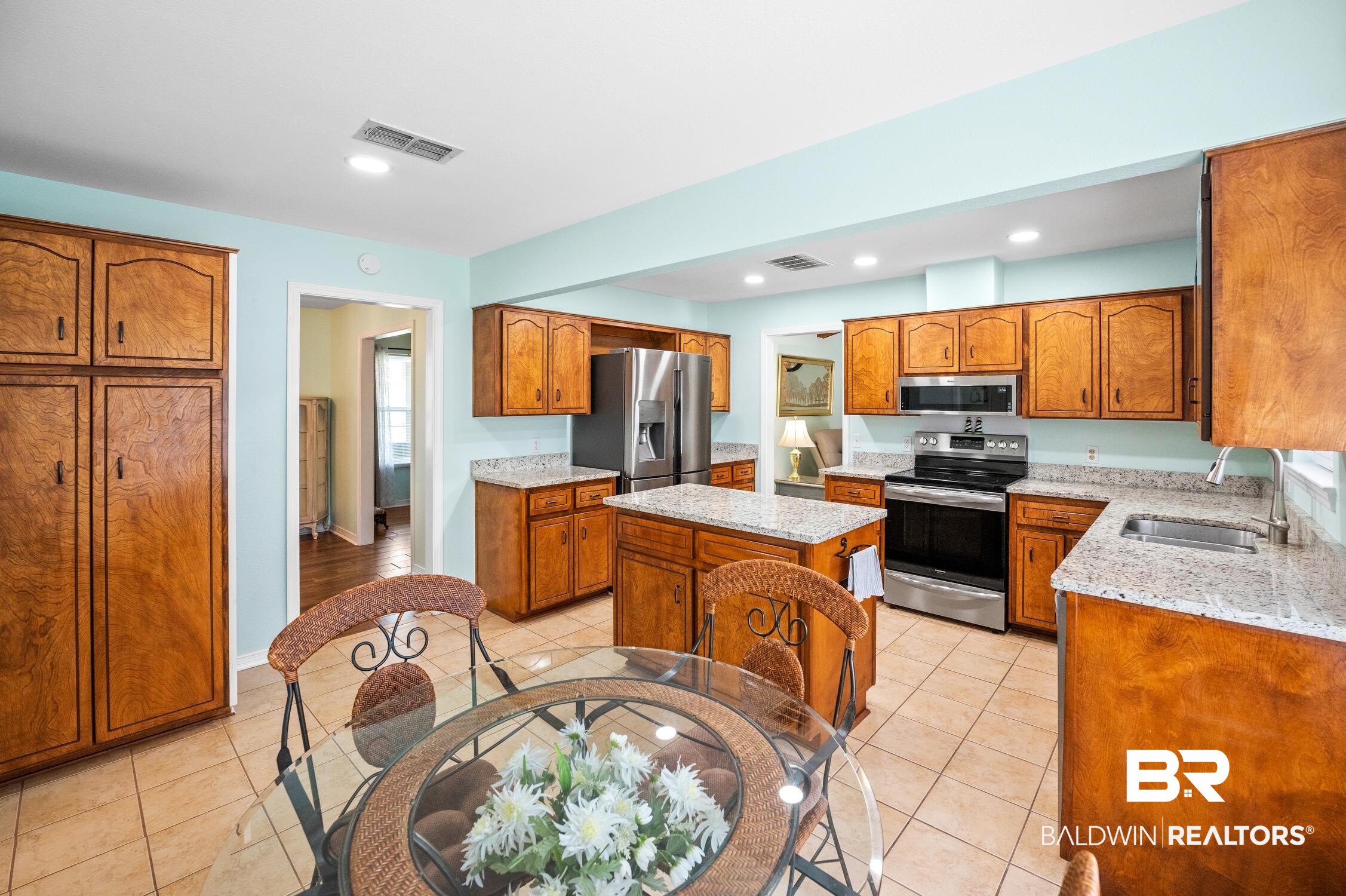 2553 Santa Rosa Drive Lillian, AL 36549 - Photo 17 of 51 Kitchen with a sink, stainless steel appliances, a kitchen island, and brown cabinets