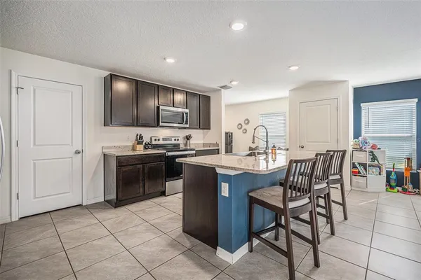 a kitchen with a sink white cabinets and stainless steel appliances