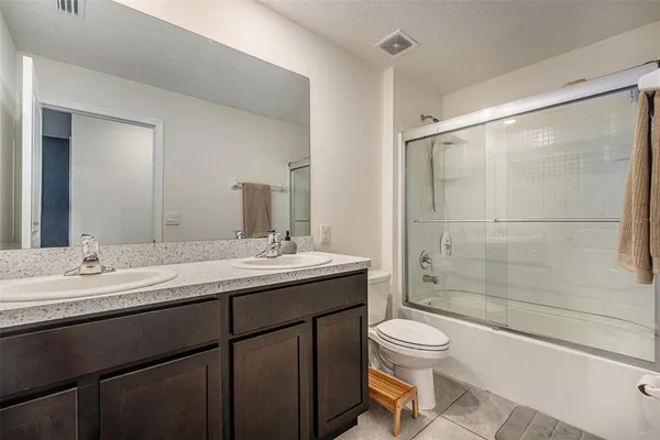 a bathroom with a granite countertop sink toilet a mirror and shower