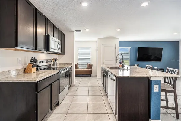a kitchen with stainless steel appliances kitchen island granite countertop a sink and cabinets